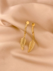 Elegant gold-tone leaf drop earrings with long snake chain tassels on champagne silk