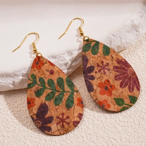 Vue détaillée de boucles d'oreilles en liège avec imprimé floral et crochets dorés