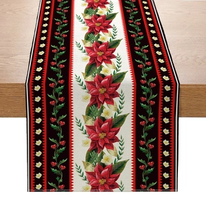 Linen Christmas table runner with red poinsettia and golden leaf patterns on wood table