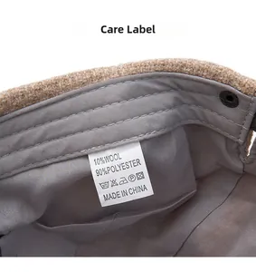 Detail view of newsboy cap care label showing 10% wool and 90% polyester blend fabric