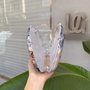 Detail view of open oval evening bag with marble pattern texture and metallic hinge