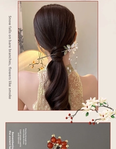 Detail of elegant gold tassel hair pin with floral accents and pearls on model