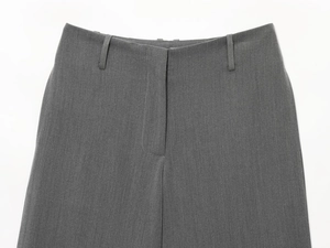 Detail of grey casual trousers featuring waist buttons, belt loops, and twill fabric texture