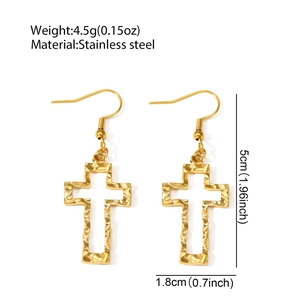 Detail of gold hollow cross earrings in stainless steel with hammered texture detail