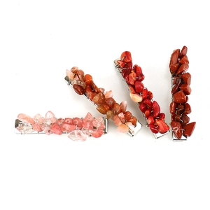 Detailed close-up of handmade natural red crystal stone hair clips on silver bases