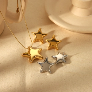 18k gold plated star necklace and earrings set displayed on elegant ceramic dish