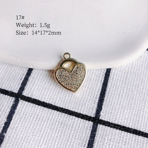 Macro shot of gold heart pendant with inlaid crystals and precise size dimensions