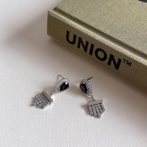Macro view of sterling silver water drop earrings with black zircon and tassels