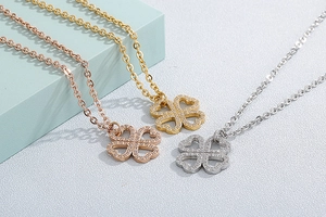 Detailed view of rhinestone clover necklaces in rose gold, gold, and silver finishes