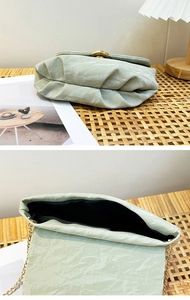 Détail du sac nuage vert clair montrant les plis, le fermoir doré et l'intérieur zippé