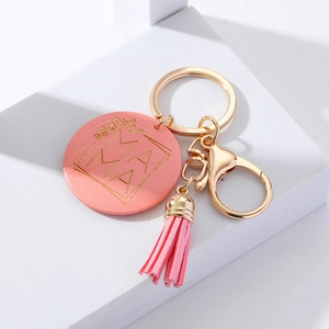 Detail of pink MAMA leopard print wooden keychain with leather tassel and gold ring