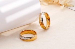 Makro-Detail von zweifarbigen Edelstahl-Partnerringen in Gold und Silber mit Zirkonia