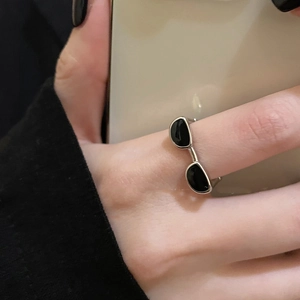 Détail d'une bague Y2K en forme de lunettes avec émail noir sur anneau argent ajustable