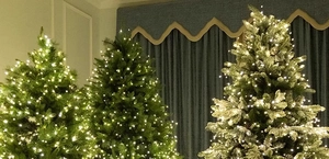 Detailed view of three decorative artificial Christmas trees with warm white LED string lights