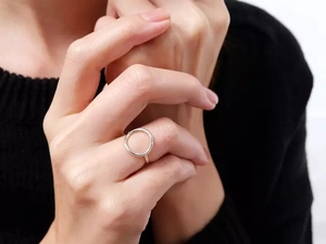 Detailed view of silver hollow geometric open ring worn on a finger for fashion display