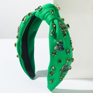 Detail of green knit headband with rhinestones, shamrocks and Irish hat accessories