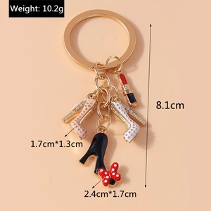 Detail of enameled high heels and lipstick charms on a gold-tone keychain accessory
