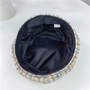 Detail of tweed beret interior featuring black satin lining and woven wash label