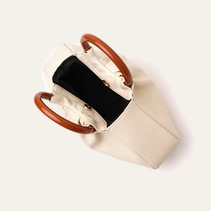 Top view of beige pleated clutch showing black interior and vintage brown wooden handles