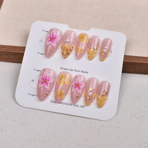 Pink and yellow stiletto press-on nails with 3D cherry blossoms, pearls and gold foil