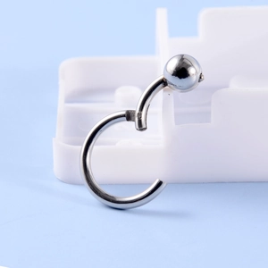 Macro shot of silver captive bead ring on white base with polished metal finish