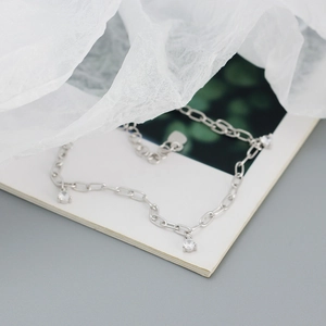 Detailed macro view of S925 sterling silver bracelet chain with three round zircon charms
