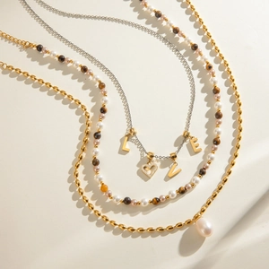 Three-layer stainless steel necklace featuring freshwater pearls and tiger eye stones