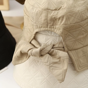 Detailed view of the khaki quilted bucket hat with a rear bow and diamond stitching