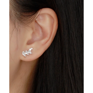 Close-up of S925 silver stud earrings with irregular zircon stones on a model's ear