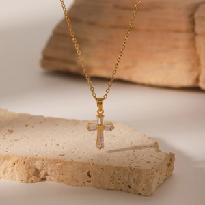 Detailed macro view of 18K gold plated cross pendant with clear baguette zircon stones