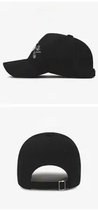 Detail of white dove embroidery on black cotton baseball cap with adjustable metal buckle