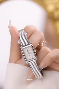 Close-up of elegant silver square watch featuring a flexible stretch chain metal band