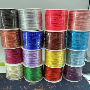 Macro view of sixteen colorful nylon cords with gold metallic thread for DIY craft jewelry