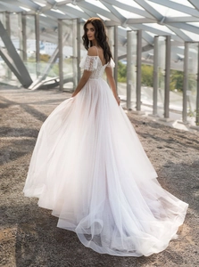 Detail of off-the-shoulder lace embroidery and layered tulle on white bridal gown