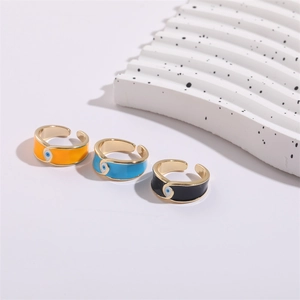 Three 14K gold-plated evil eye enamel rings in orange, blue, and black finishes