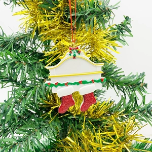 Detail of resin Christmas family fireplace pendant with red glitter socks on tree