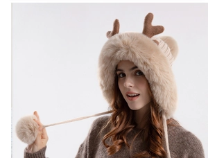 Detail of plush deer antler hat featuring knitted ear flaps and soft decorative fur pom-poms