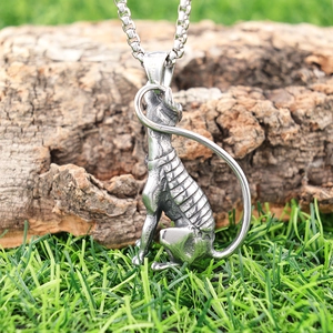 Detailed close-up of vintage stainless steel Egyptian cat Bastet pendant on tree bark