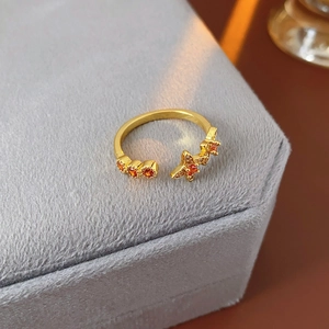 Vintage Goldring mit orangen Steinen auf grauem Samt präsentiert für elegantes Schmuckdesign
