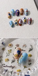 Macro shot of vintage floral 3D embossed nail stickers featuring daisy and pansy designs