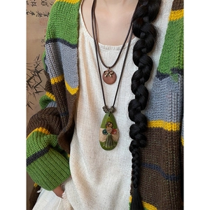 Detailed shot of bohemian style teardrop necklace with buttons, tassels and bow accents
