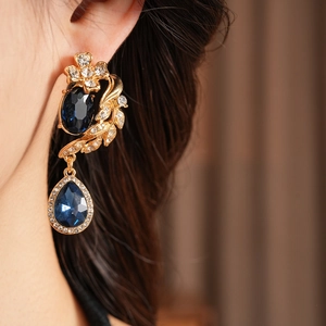 Gros plan de boucles d'oreilles vintage avec pierres bleues et diamants scintillants