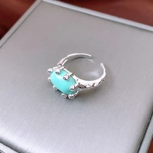 Macro detail of vintage 18K gold plated oval turquoise ring with hammered texture metal