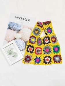 Close-up of yellow crochet tote bag with colorful bohemian sunburst flower patterns