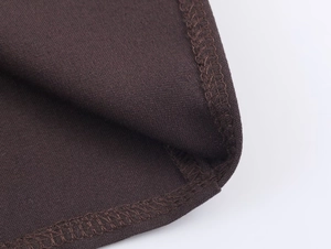 Close-up of the dense dark brown woven fabric texture and professional overlock stitching