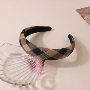 Detail of classic black and beige checkered fabric headband with padded retro style