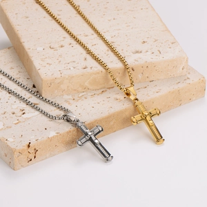 Gold and silver cross necklaces with box chains on stone textures, minimalist jewelry