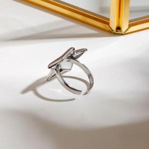 Minimalist adjustable stainless steel ring with a polished star motif shown at a 45-degree angle