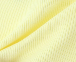 Primer plano macro de la textura de punto acanalado amarillo claro del conjunto cárdigan