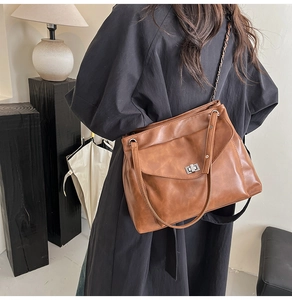 Vista dettagliata della borsa a tracolla vintage marrone con catena su una modella